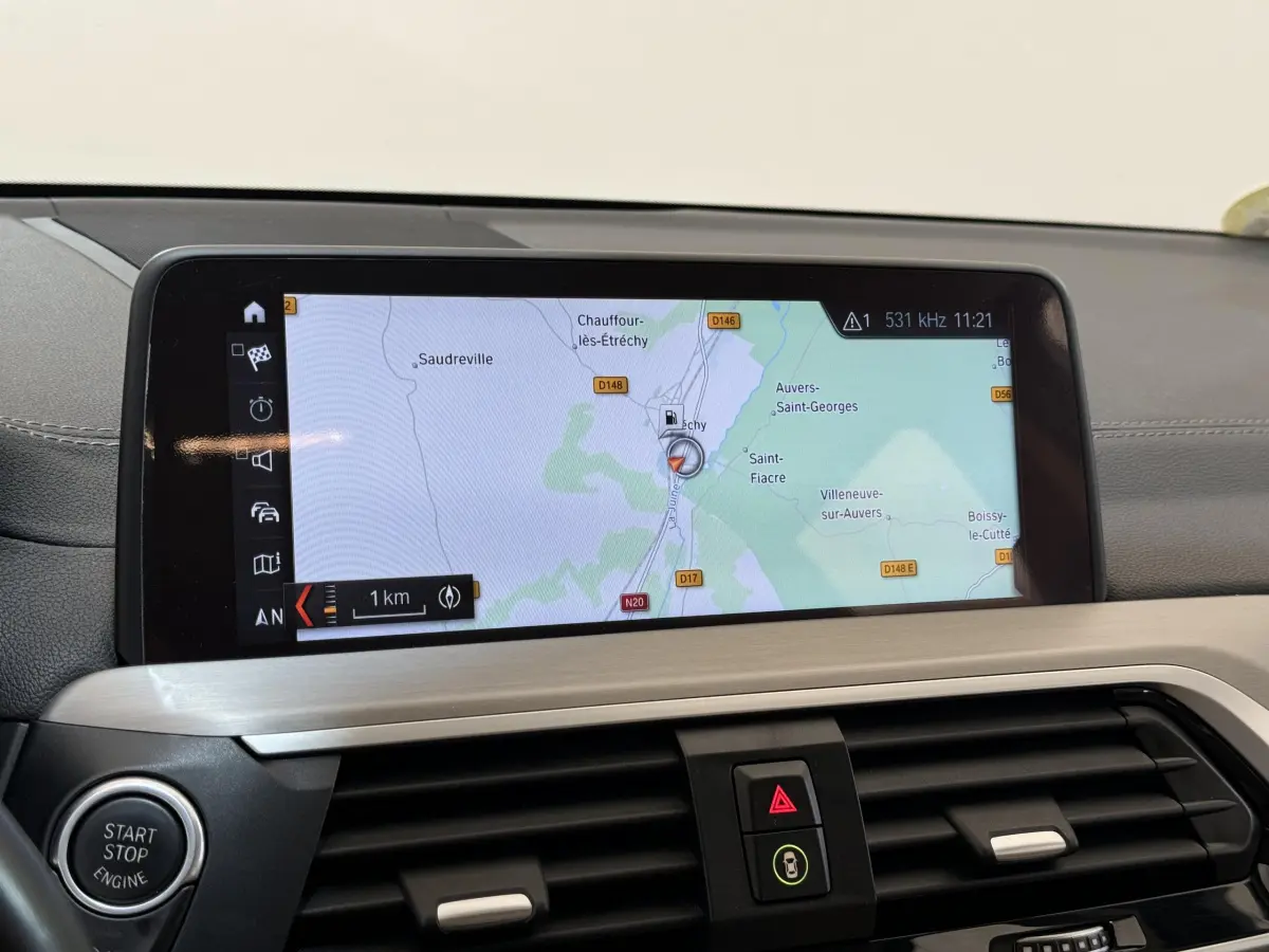 Vue intérieure du tableau de bord du BMW X3 gris foncé de 2018, avec écran tactile de navigation 10,3 pouces.