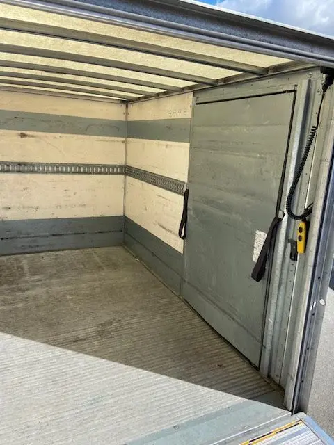 Intérieur de la caisse grise du Ford Transit Chassis Cabine jaune, vue depuis l'arrière avec hayon ouvert.