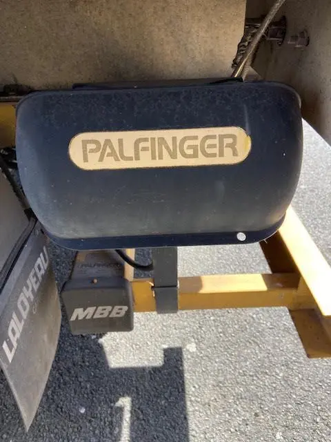 Gros plan sur le hayon hydraulique Palfinger fixé à la caisse jaune du Ford Transit Chassis Cabine 2015.