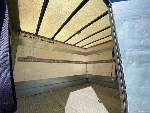 Vue intérieure de la caisse 12m3 du Ford Transit Chassis Cabine jaune, montrant l'espace de chargement vide avec hayon ouvert.