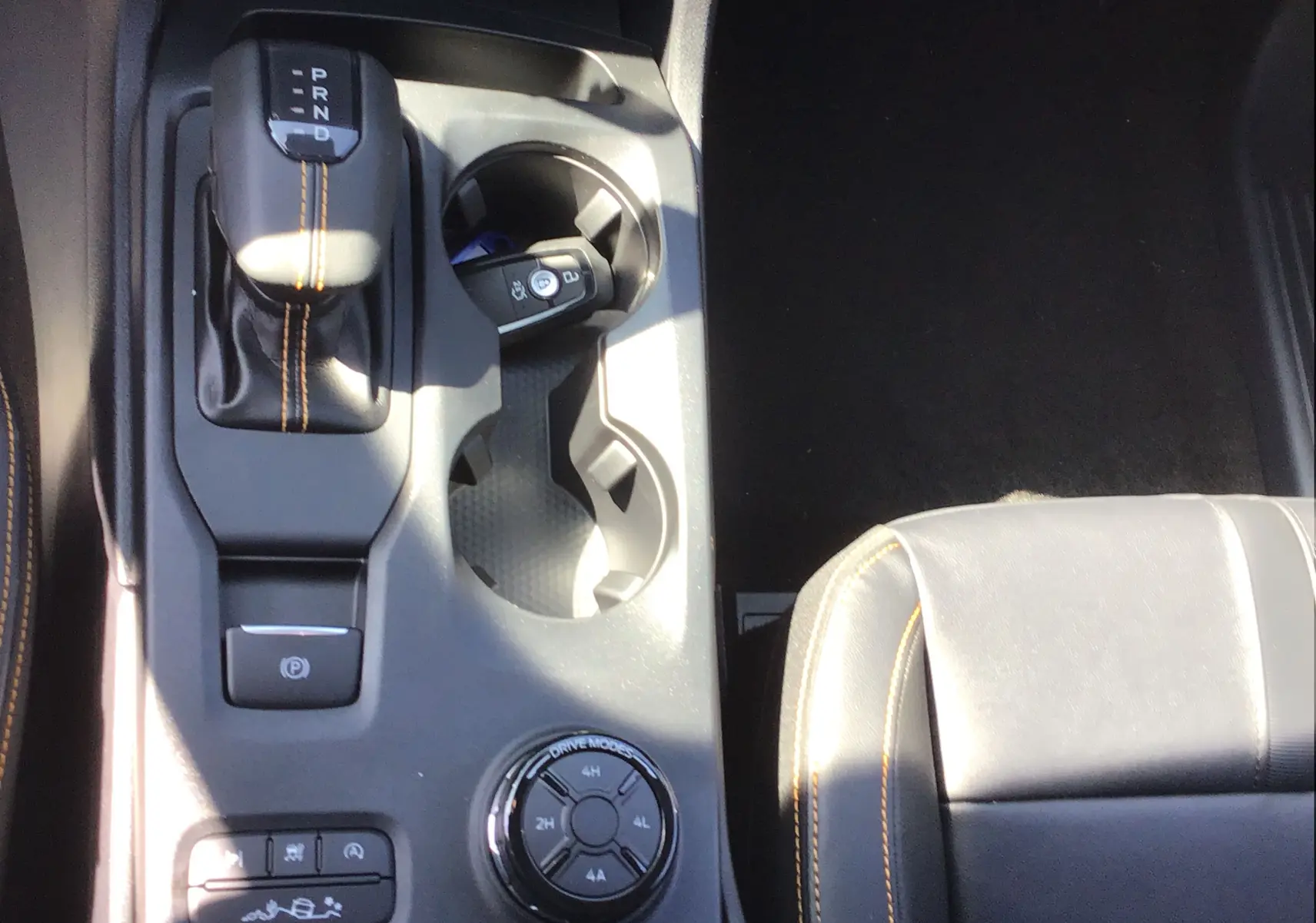 Vue plongeante sur la console centrale noire du Ford Ranger Wildtrak 2025 avec levier de vitesses et sellerie cuir gris carbone.