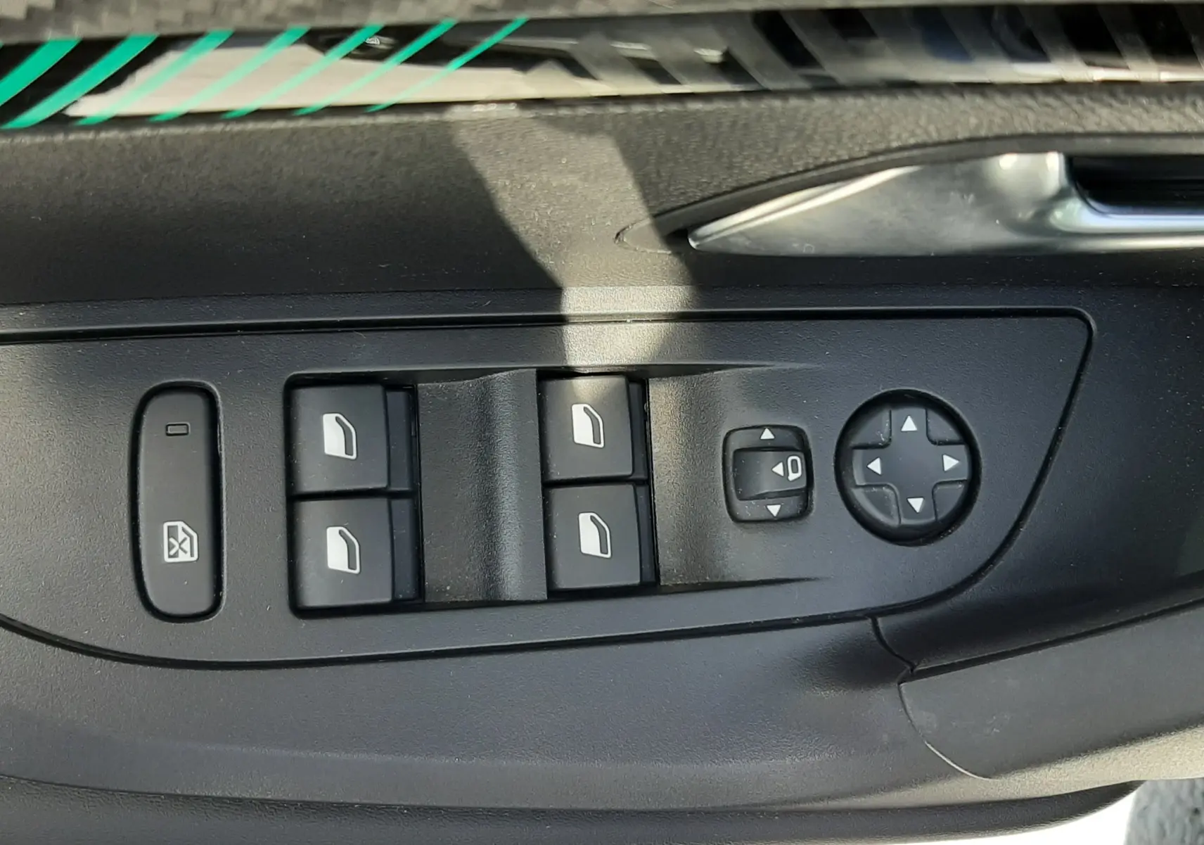 Panneau de commandes des vitres et rétroviseurs côté conducteur d'un Peugeot 2008 gris Artense 2022.