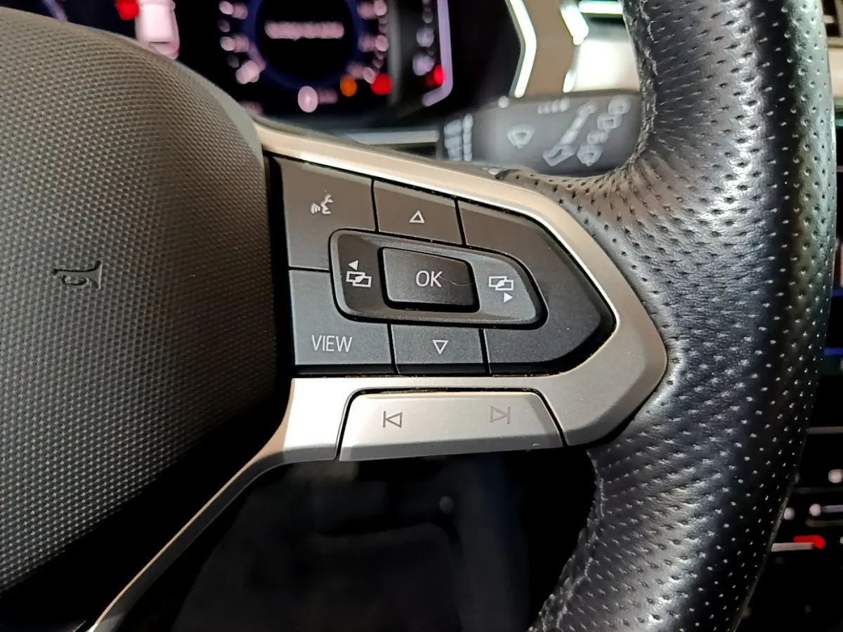 Gros plan sur les commandes du volant en cuir noir de la Volkswagen Passat hybride rechargeable 2022, côté gauche.