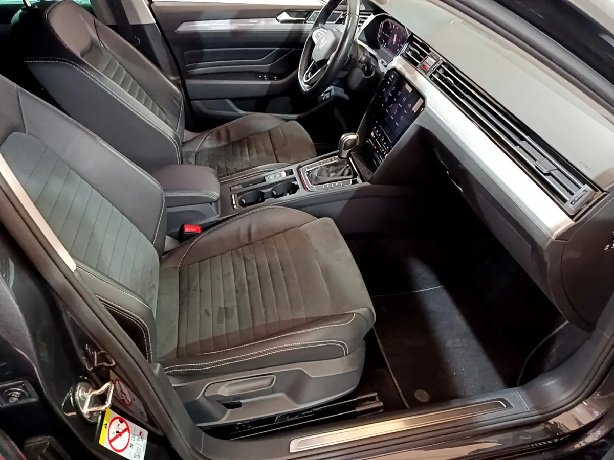 Intérieur avant droit de la Volkswagen Passat hybride rechargeable 2022, sièges gris foncé et tableau de bord moderne tactile.