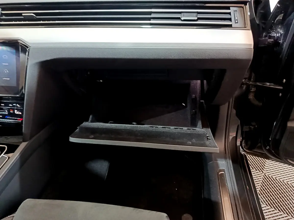 Gros plan sur la boîte à gants ouverte côté passager de la Volkswagen Passat GTE gris foncé 2022.