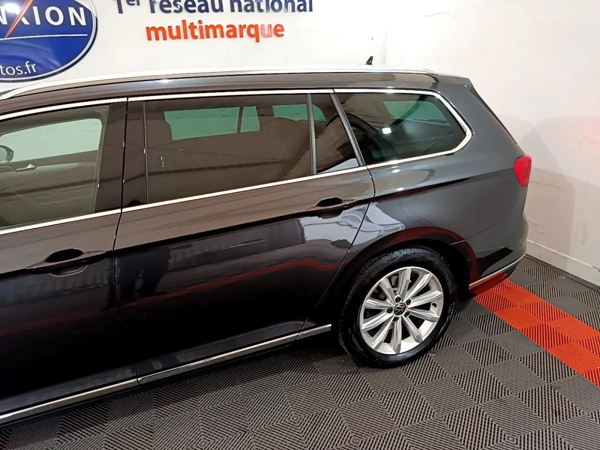 Vue latérale droite d'un break Volkswagen Passat gris foncé avec jantes alliage et vitres teintées.