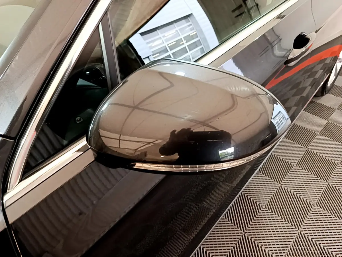 Rétroviseur côté gauche gris foncé de la Volkswagen Passat hybride rechargeable 2022 avec clignotant intégré.