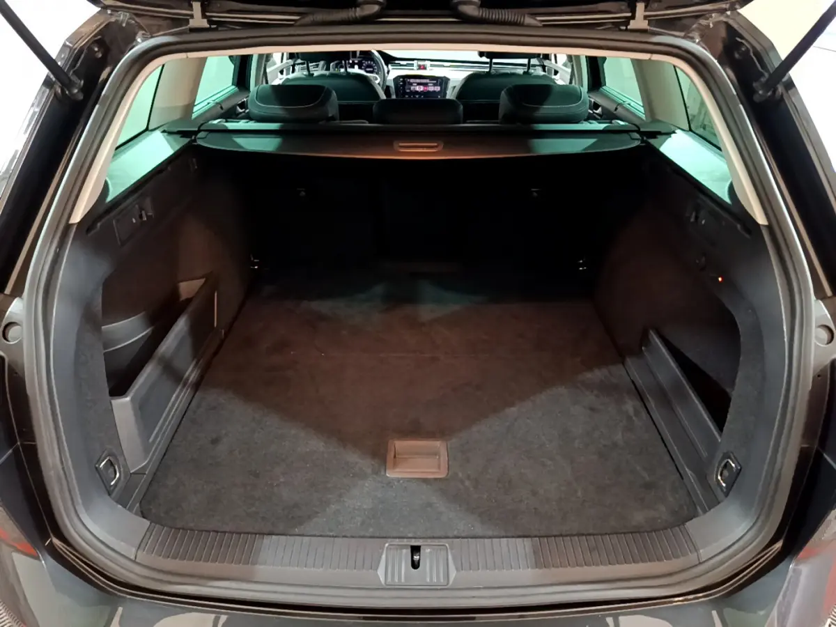 Coffre ouvert vue arrière d'une Volkswagen Passat SW GTE gris foncé, montrant un espace de chargement spacieux et propre.