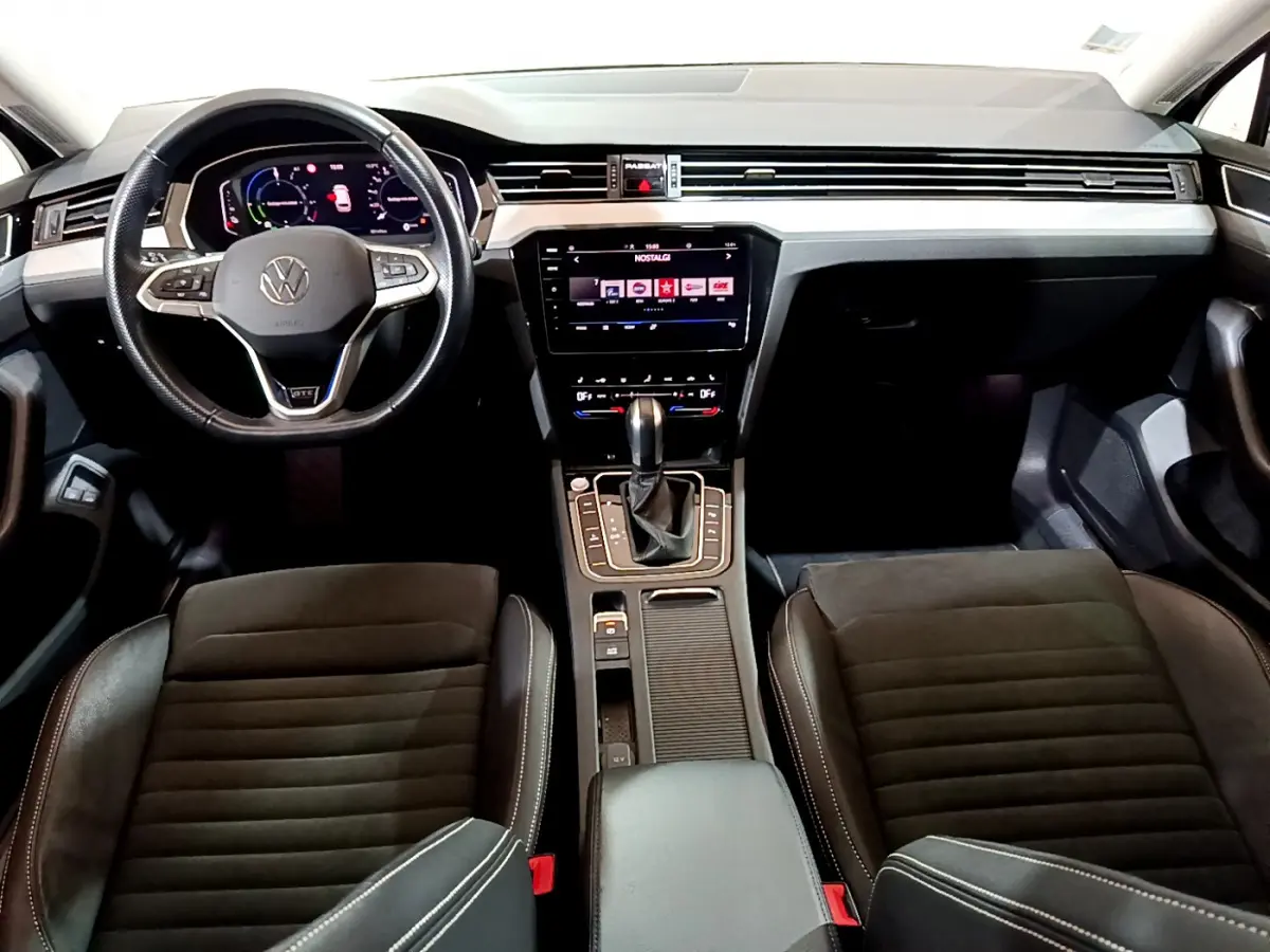 Intérieur avant de la Volkswagen Passat GTE 2022, tableau de bord noir avec écran tactile et volant cuir multifonctions.