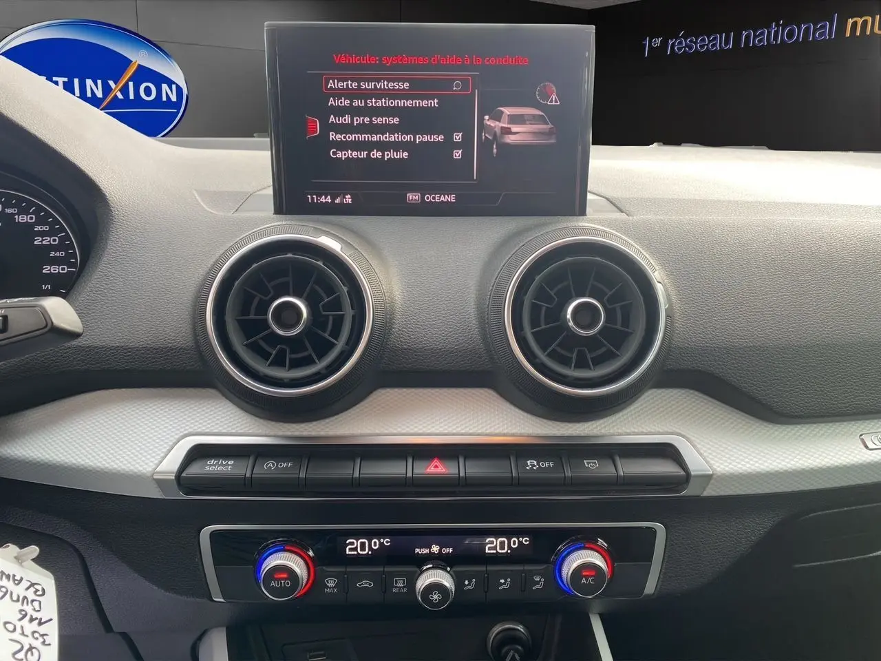 Tableau de bord de l'Audi Q2 30 TDI 2019 avec écran central affichant les aides à la conduite et commandes de climatisation double zone.