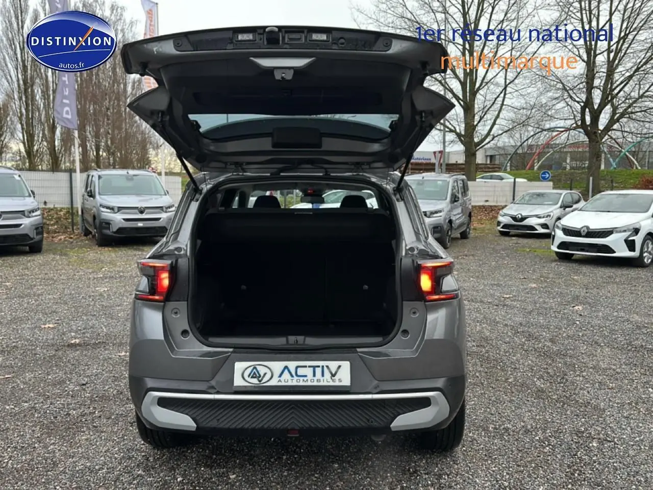 Vue arrière d’un Citroën C3 Aircross gris 2025 avec coffre ouvert et feux arrière allumés.