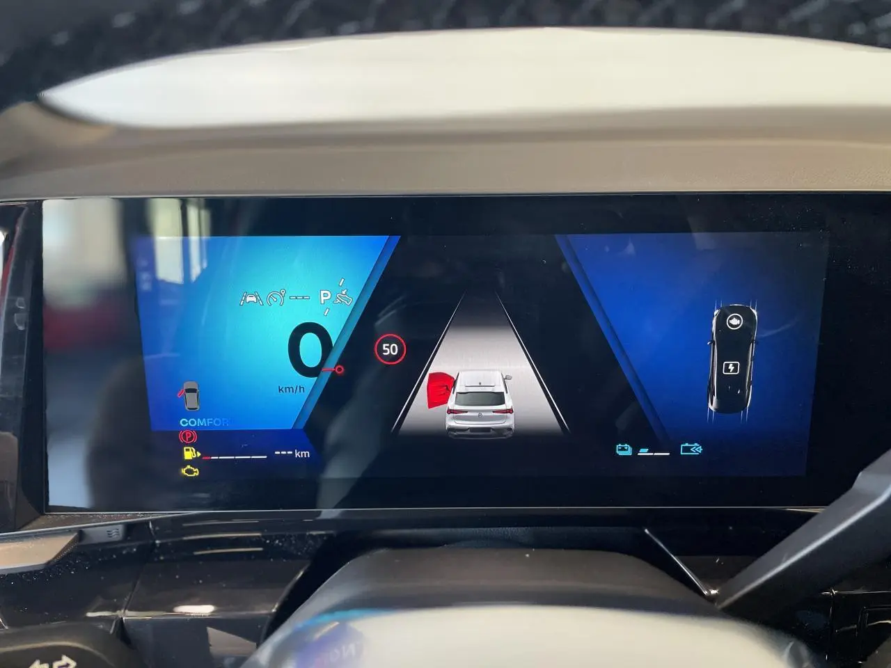 Tableau de bord numérique de Renault Rafale 2025 affichant l’aide au stationnement et la vitesse à 0 km/h.