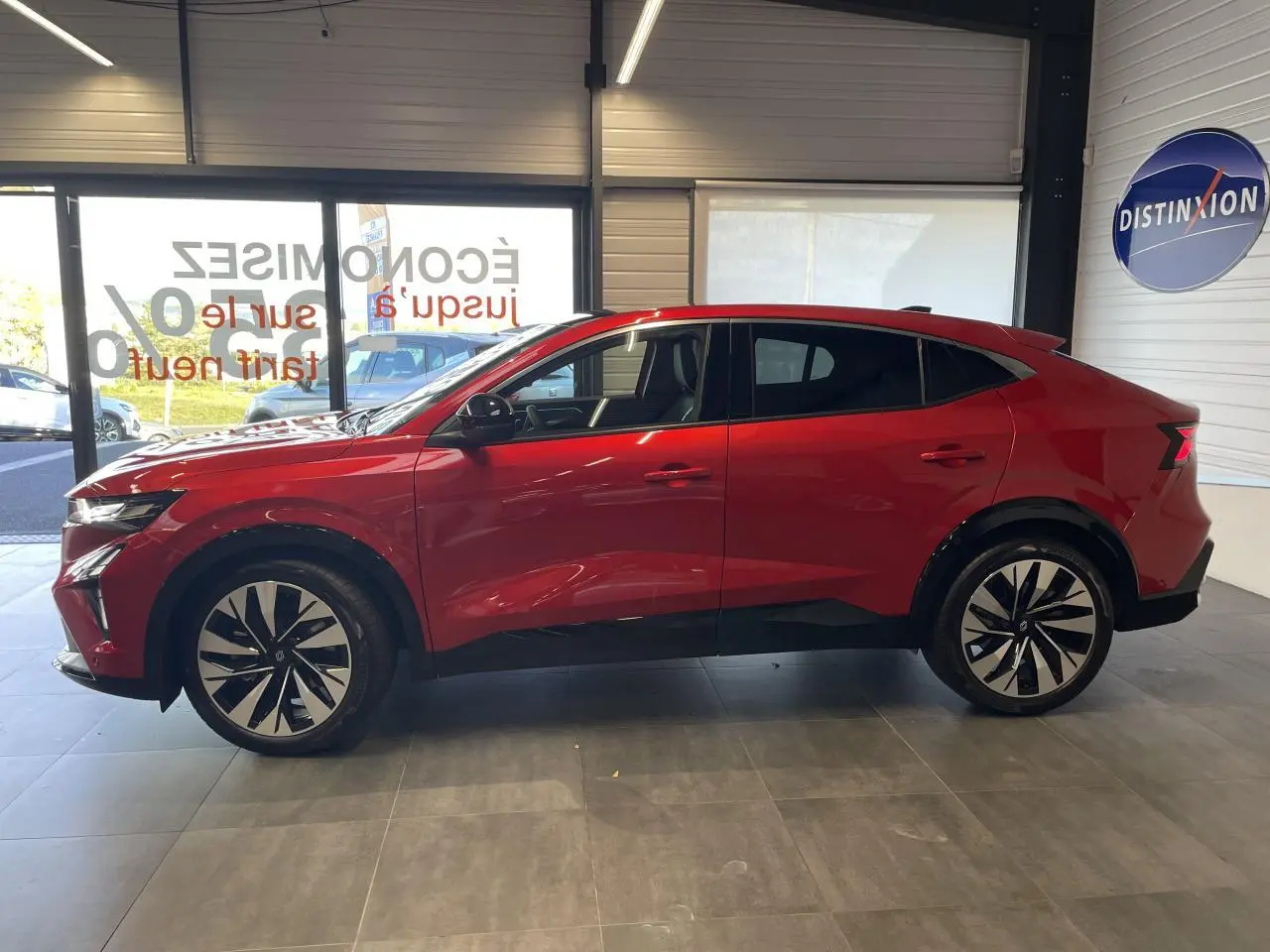 Vue de profil côté gauche d'un Renault Rafale 2025 rouge Flamme avec toit noir et jantes alliage noires diamantées.