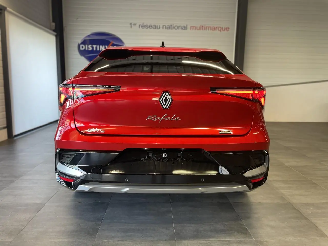 Vue arrière d'une Renault Rafale rouge à toit noir, avec feux LED fins et logo central brillant.