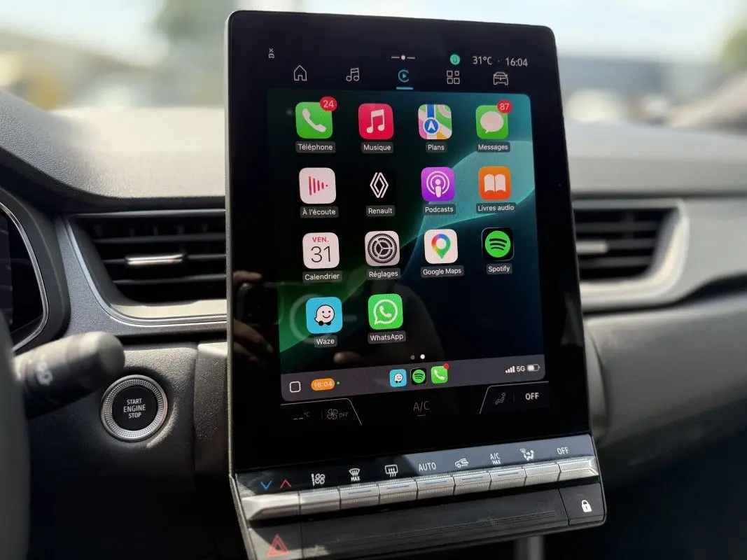 Écran tactile central vertical du Renault Captur 2025 affichant des applications connectées, avec bouton start/stop à gauche.