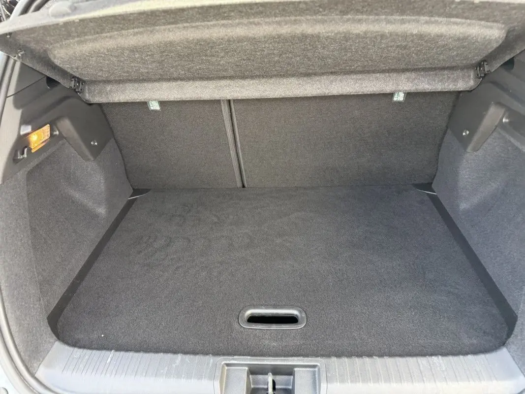 Coffre ouvert du Renault Captur 2025 gris Rafale avec toit noir, vue de l'arrière montrant l'espace de chargement vide.