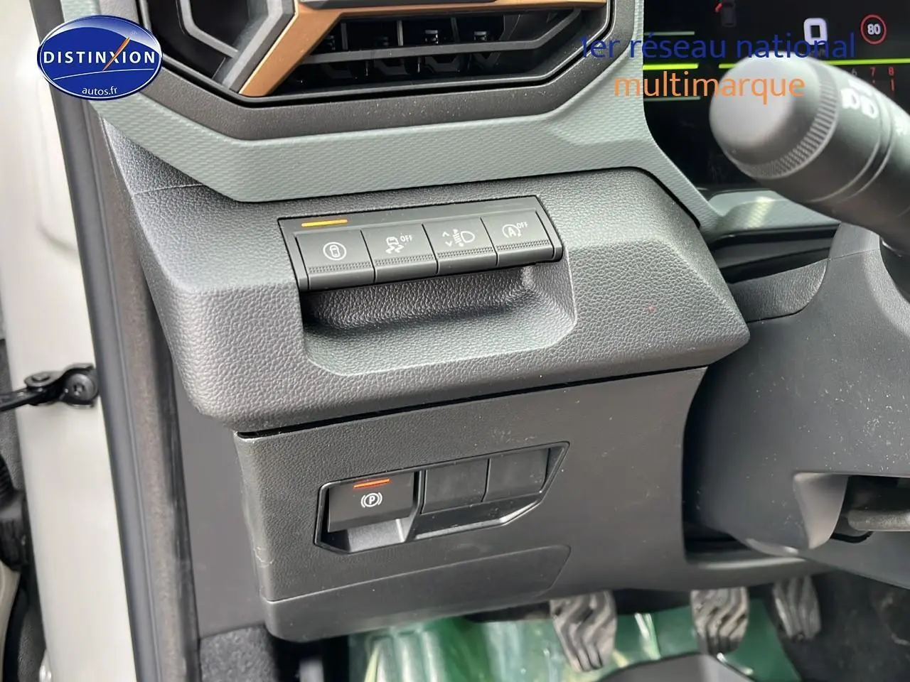Gros plan sur les commandes sous le tableau de bord côté gauche du Dacia Duster Sandstone 2025.