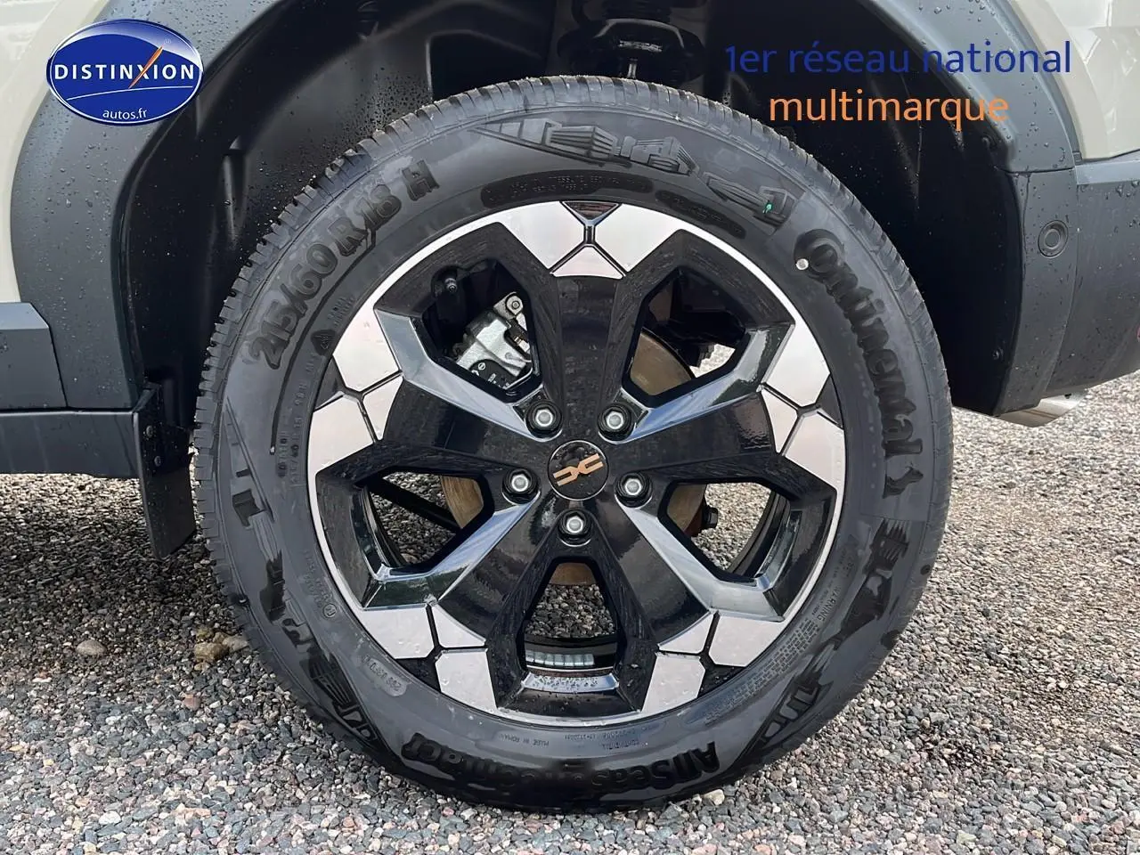 Gros plan sur la roue avant gauche du Dacia Duster 2025 couleur Sandstone avec jante 18 pouces semi diamantée noire et grise.