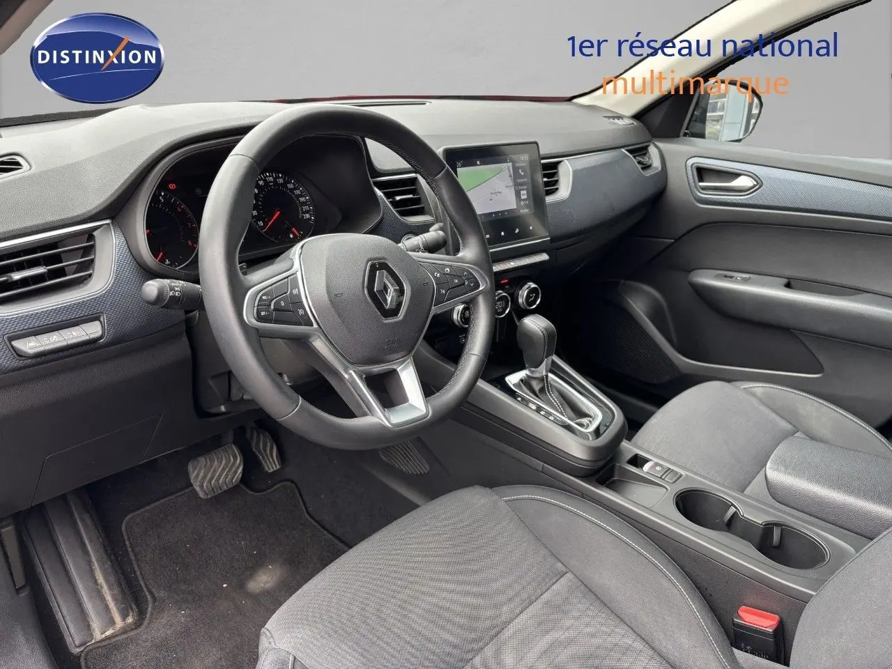 Intérieur du Renault Arkana 2022, vue côté conducteur sur le tableau de bord, volant multifonction et console centrale noire.