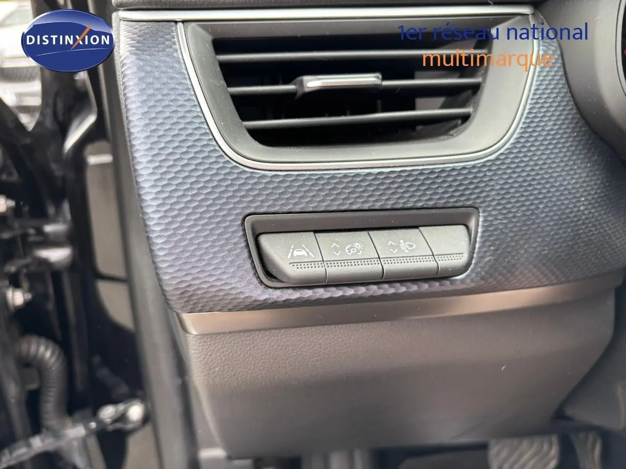 Détail intérieur montrant les commandes d'aide à la conduite sous une sortie d'air sur Renault Arkana noir métal 2022