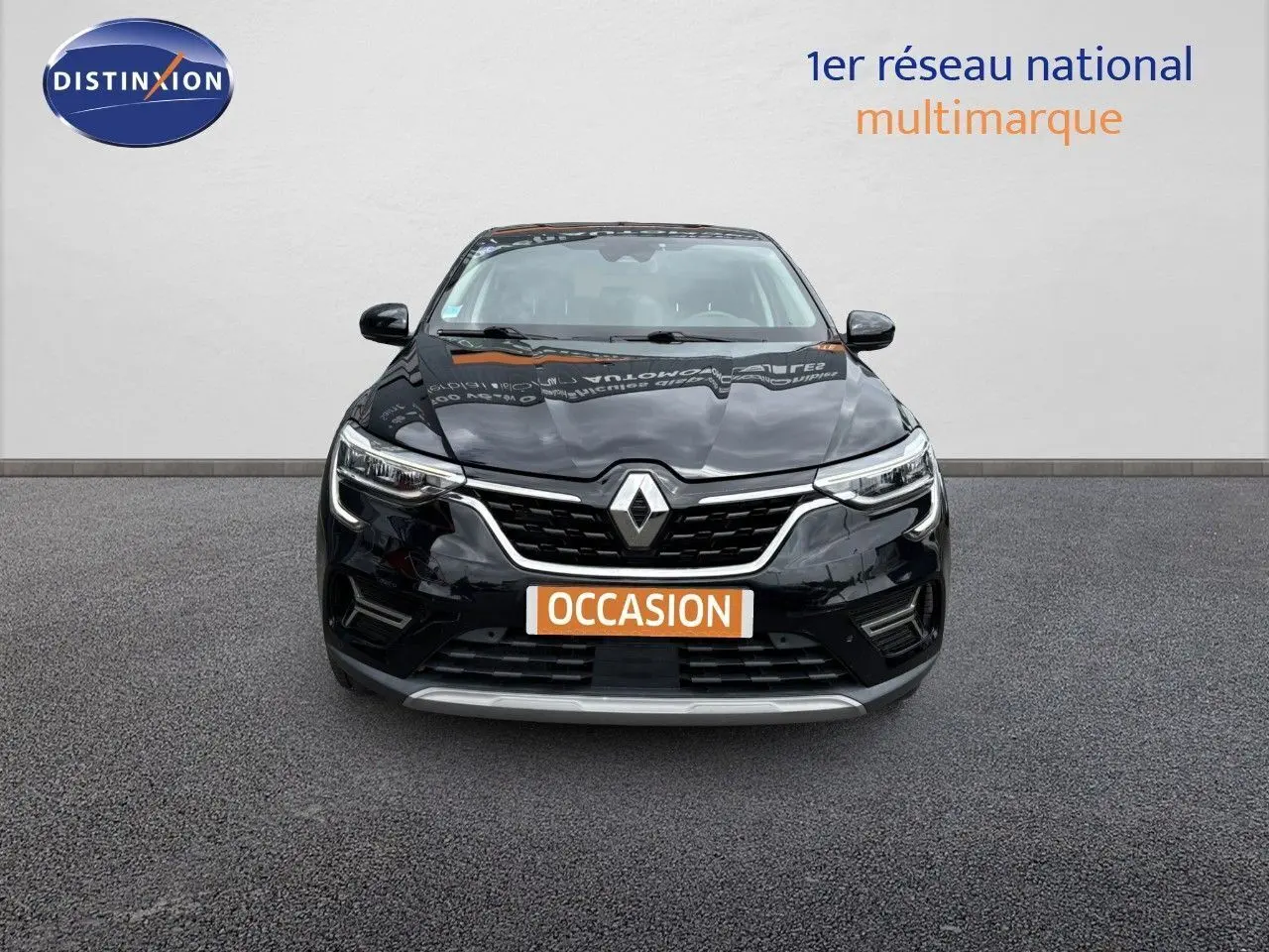 Vue frontale d'un Renault Arkana noir métal 2022 avec calandre chromée et feux LED allumés.