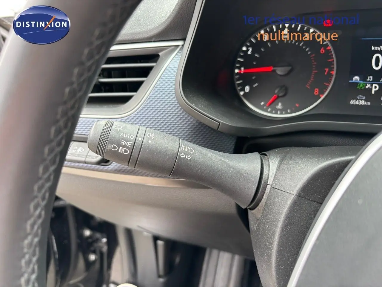 Gros plan sur la manette des feux et clignotants du tableau de bord d'une Renault Arkana noir métal 2022.