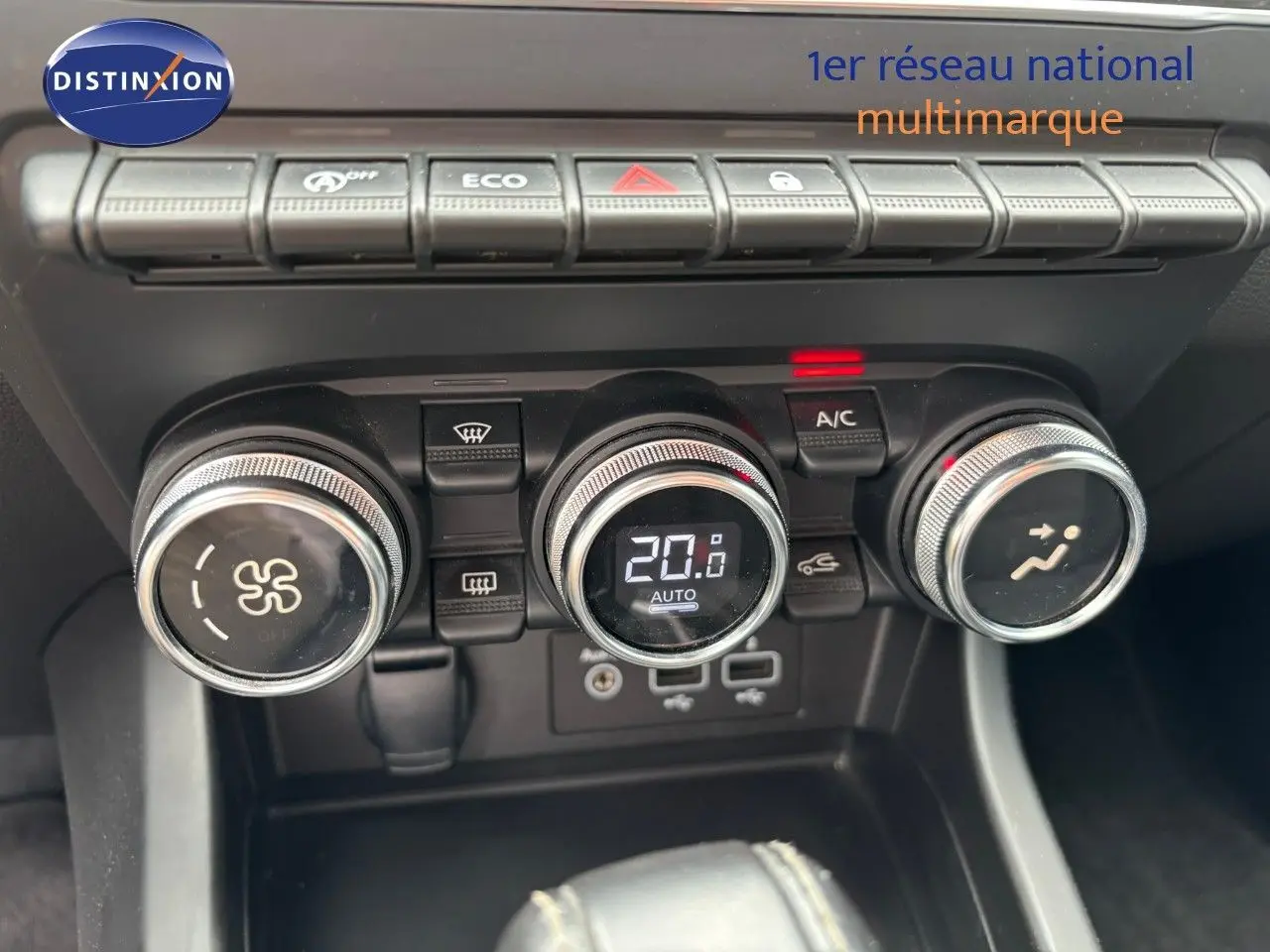 Gros plan sur la console centrale de la Renault Arkana noire, montrant les commandes de climatisation et les boutons fonctionnels.