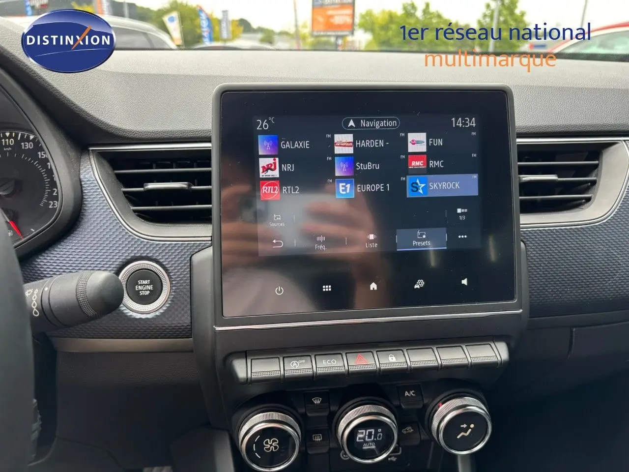 Tableau de bord de Renault Arkana 2022 avec écran tactile central affichant stations radio, boutons de commande et démarrage sans clé.