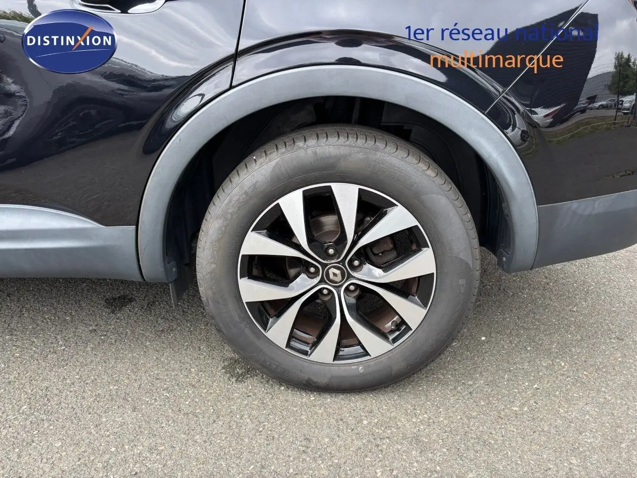 Gros plan sur la roue arrière droite d'un Renault Arkana noir métal avec jante alliage bicolore.