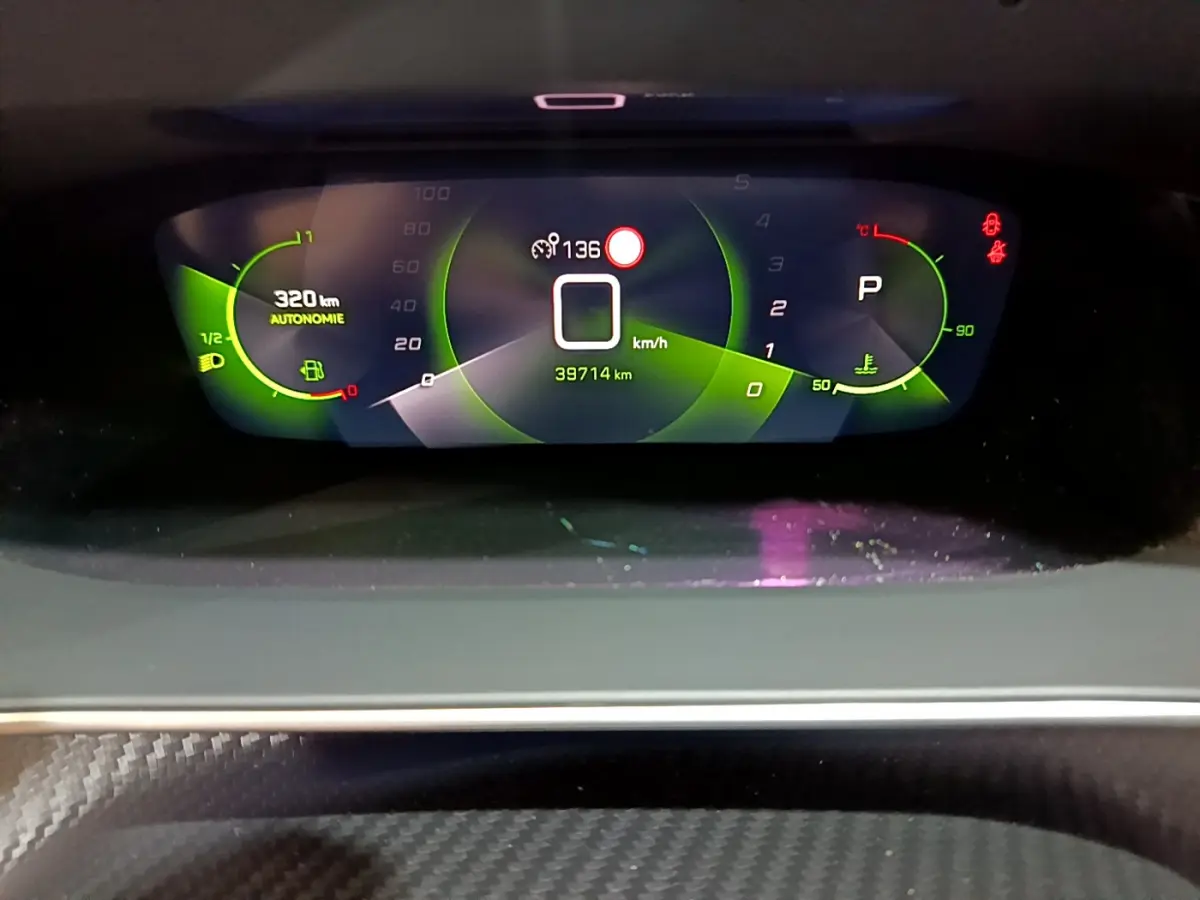 Affichage numérique du tableau de bord de la Peugeot 208 jaune, montrant vitesse zéro et autonomie 320 km.