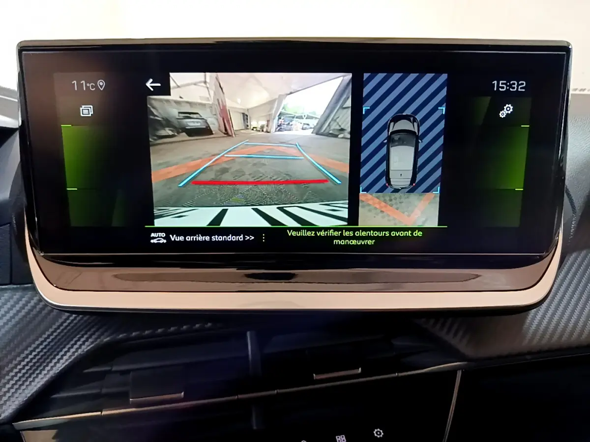 Écran tactile central de la Peugeot 208 affichant la caméra de recul et l'aide au stationnement arrière.