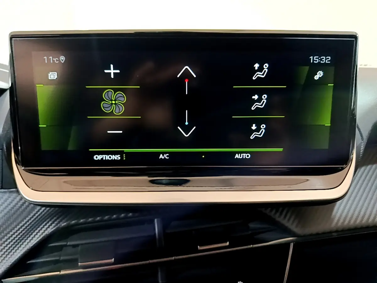 Écran tactile central du tableau de bord de la Peugeot 208 jaune 2023 affichant les réglages de climatisation automatique.