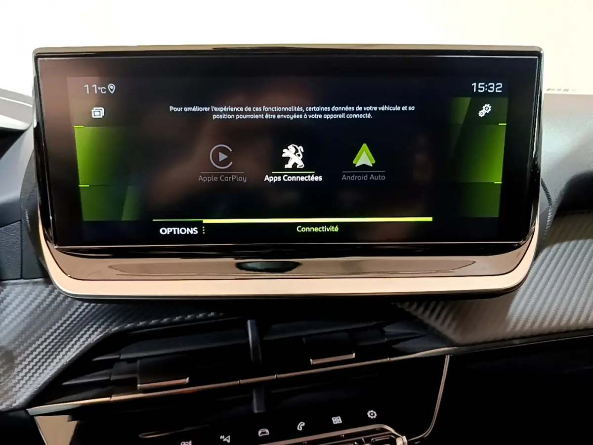 Écran tactile central de la Peugeot 208 jaune 2023 affichant les options Apple CarPlay et Android Auto.