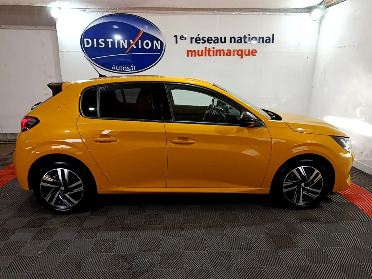 Profil côté gauche d'une Peugeot 208 jaune 2023, finition Allure Pack, dans un showroom lumineux.