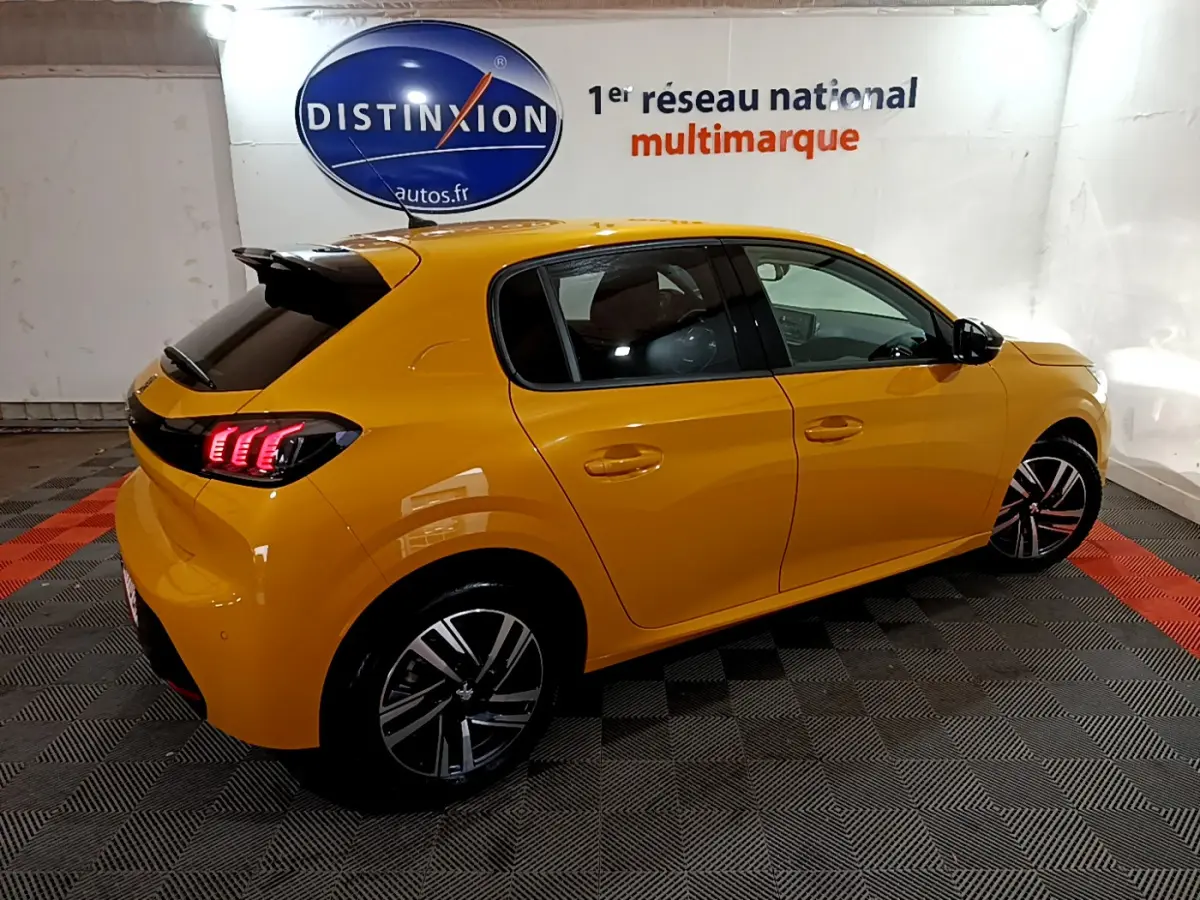 Peugeot 208 jaune vue en 3/4 arrière côté droit, avec feux LED et jantes alliage distinctives.