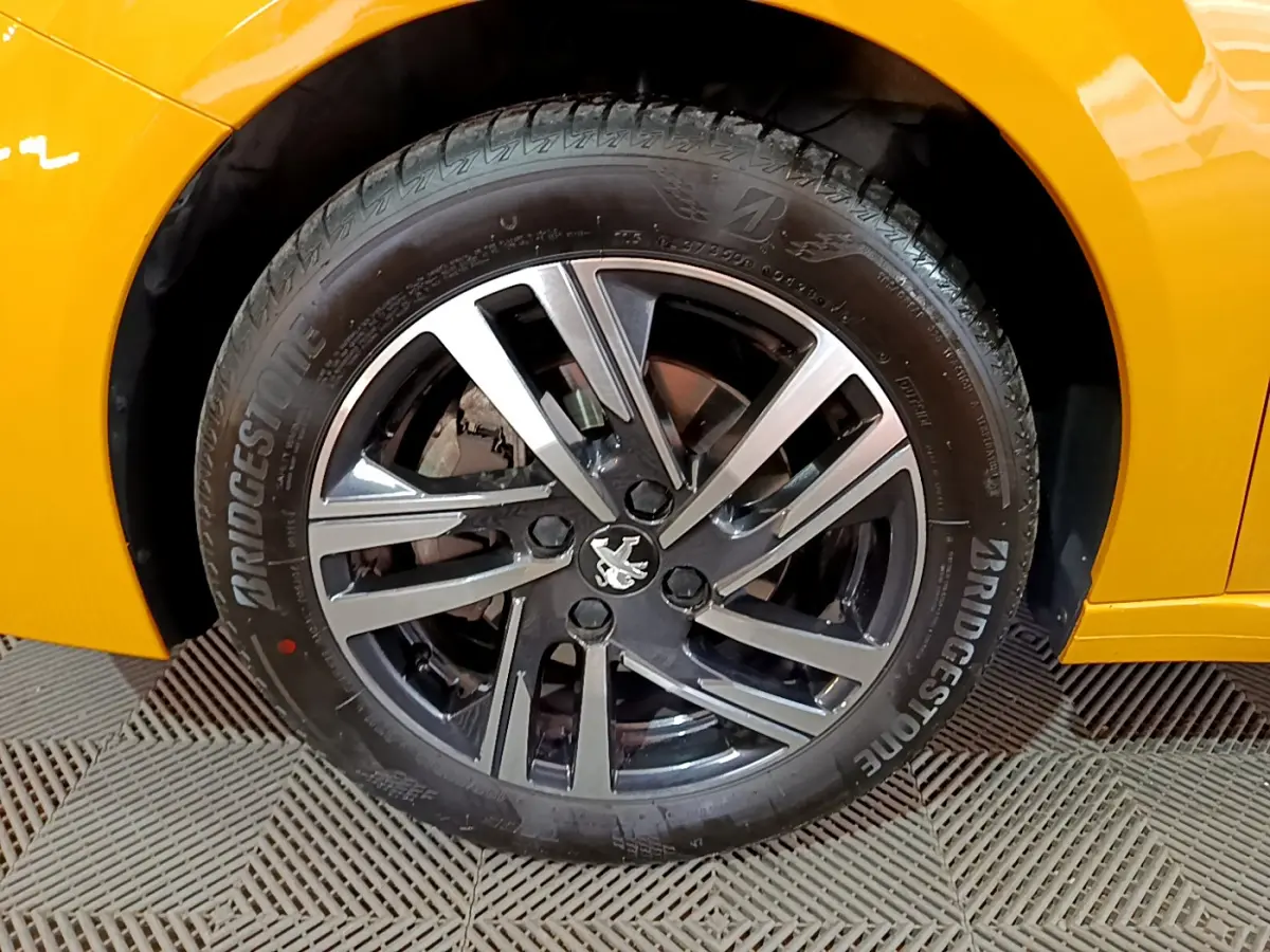 Gros plan sur la roue avant gauche de la Peugeot 208 jaune avec jante alliage et pneu Bridgestone.