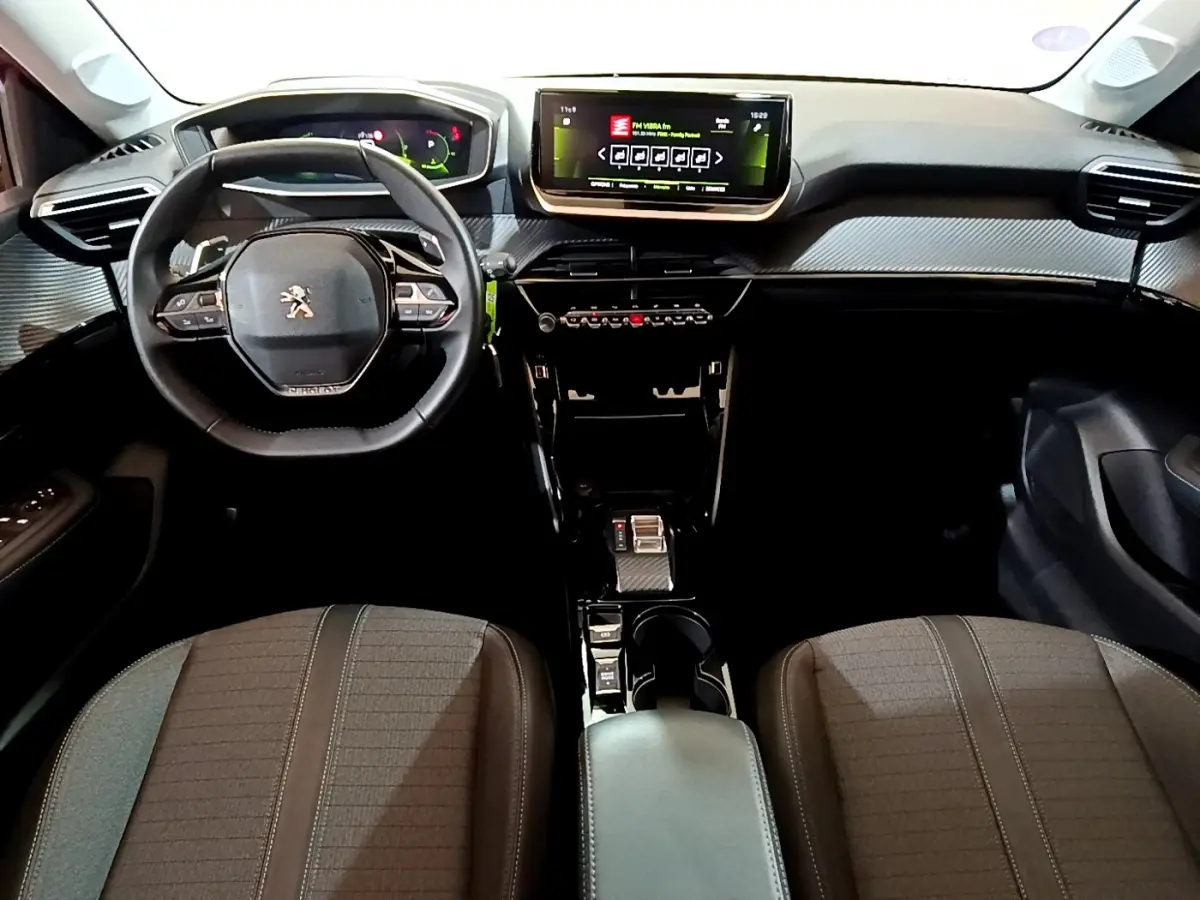 Vue intérieure avant de la Peugeot 208 2023 avec tableau de bord numérique et écran tactile central lumineux