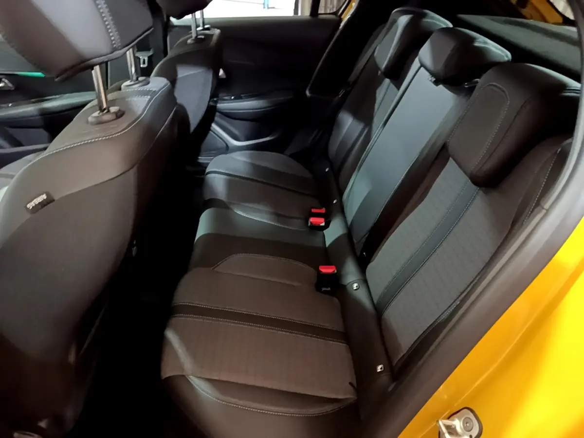 Vue intérieure côté droit sur la banquette arrière noire de la Peugeot 208 jaune 2023 Allure Pack.