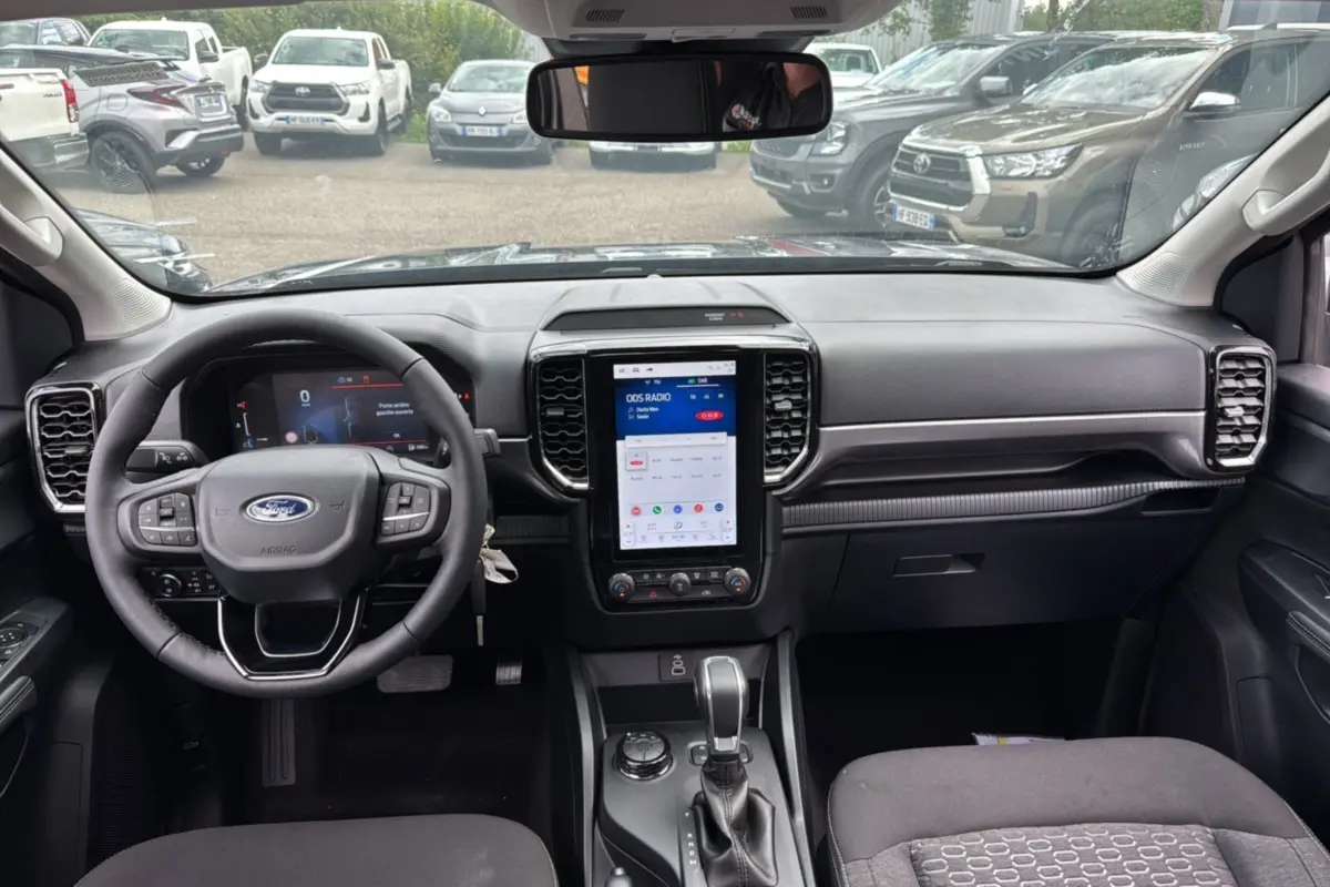 Vue intérieure du Ford Ranger 2025 gris carbone, avec tableau de bord moderne et écran tactile vertical central.