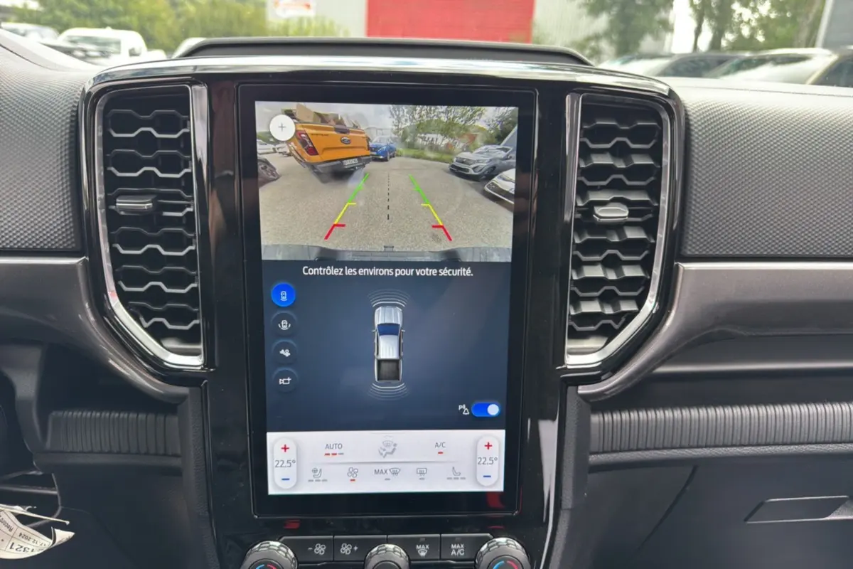 Écran tactile central du Ford Ranger 2025 gris carbone montrant la caméra de recul et les capteurs de stationnement.