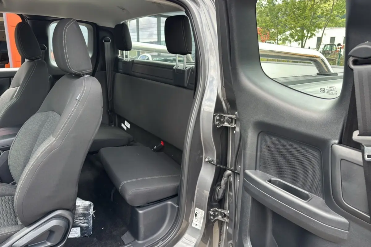 Vue intérieure côté droit du Ford Ranger 2025 gris carbone Supercab, montrant les sièges avant et banquette arrière compacte.