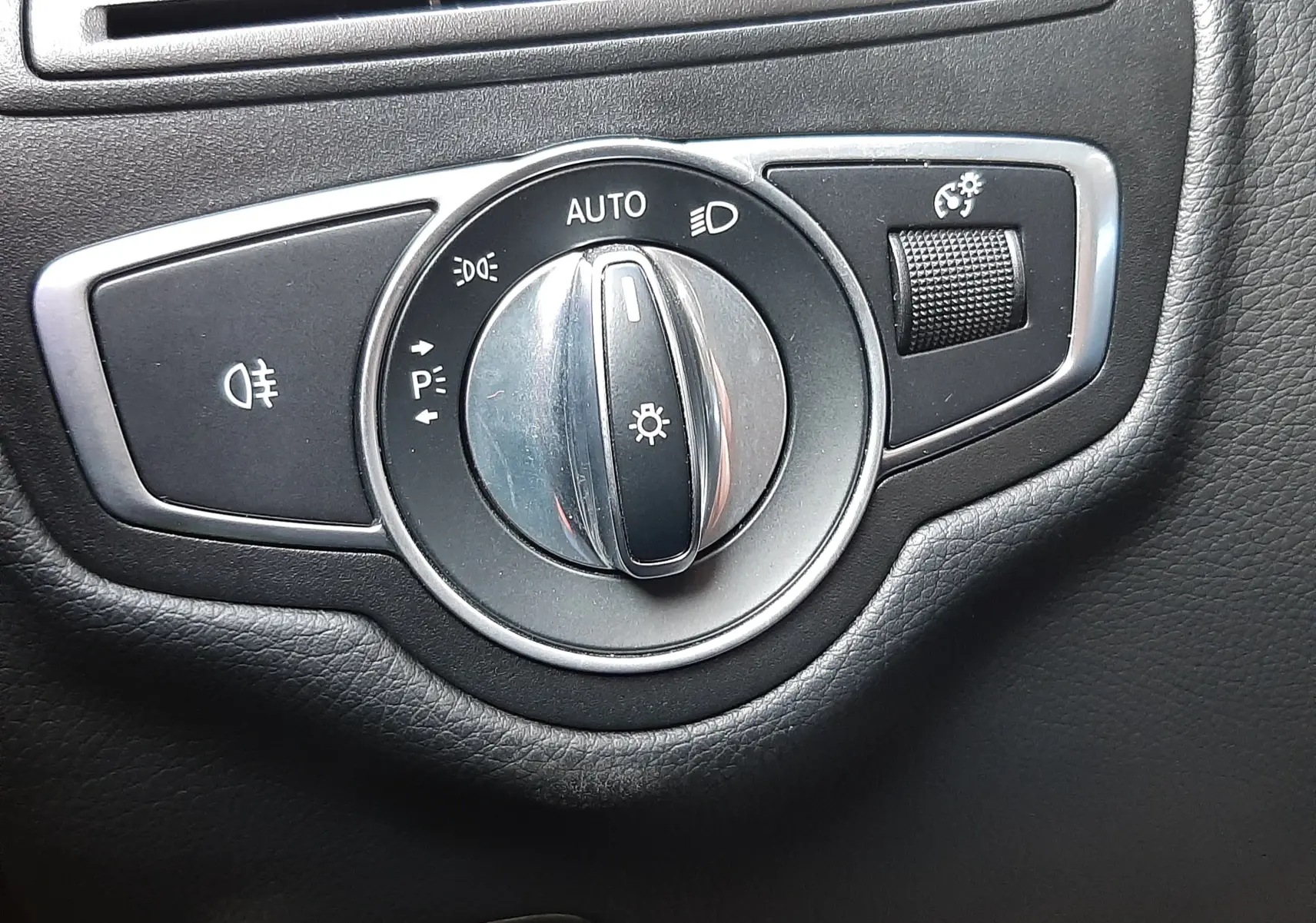 Gros plan sur les commandes de lève-vitres et réglage des rétroviseurs côté conducteur d’un Mercedes GLC Coupé blanc 2019.