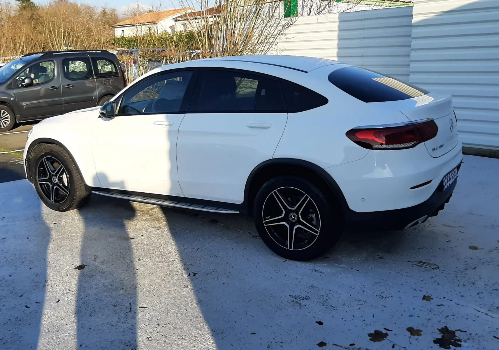 Bouton rouge "STOP" pour ouverture/fermeture du hayon, situé à l'intérieur arrière d'un Mercedes GLC Coupé blanc.