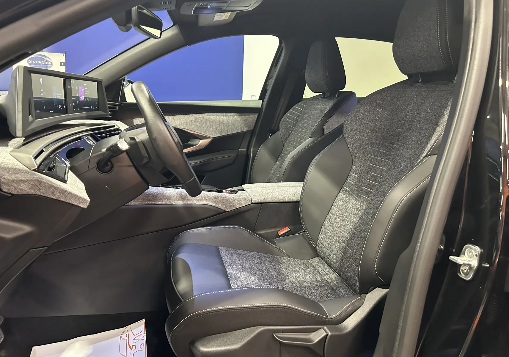 Intérieur du Peugeot 3008 III Hybrid 145 vue côté gauche, sièges bi-matière gris et noir avec tableau de bord numérique.