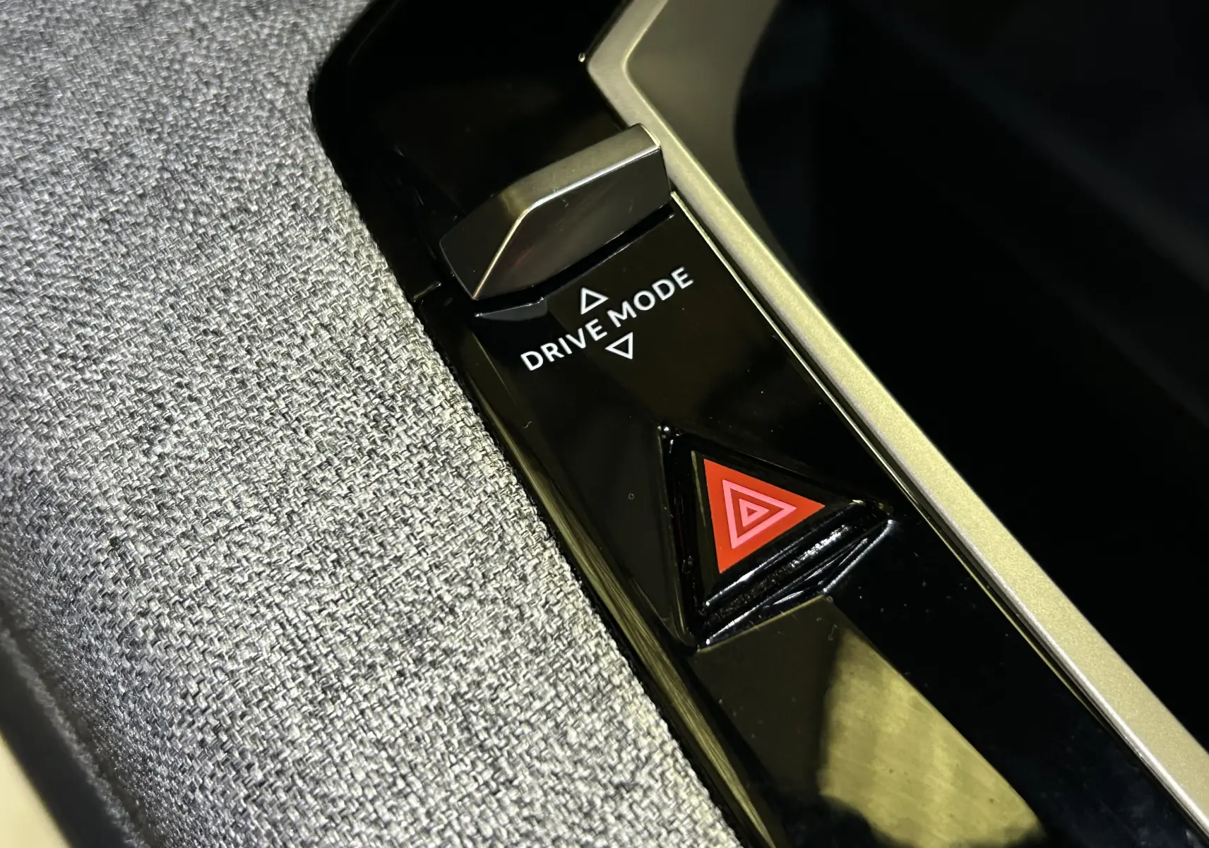 Gros plan sur les boutons Drive Mode et warning sur la console centrale du Peugeot 3008 III Hybrid 145 finition Allure.