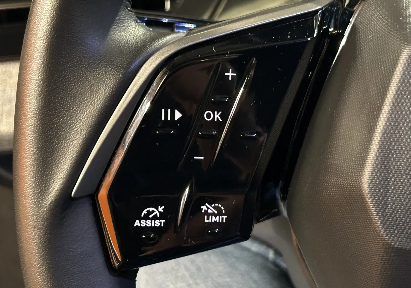 Gros plan sur les commandes noires du volant côté gauche du Peugeot 3008 III Hybrid 145 e-DSC6 Allure 2025.
