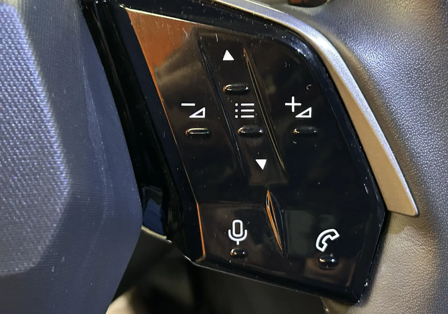 Gros plan sur les commandes tactiles noires du volant du Peugeot 3008 III Hybrid 145 e-DSC6 Allure 2025.