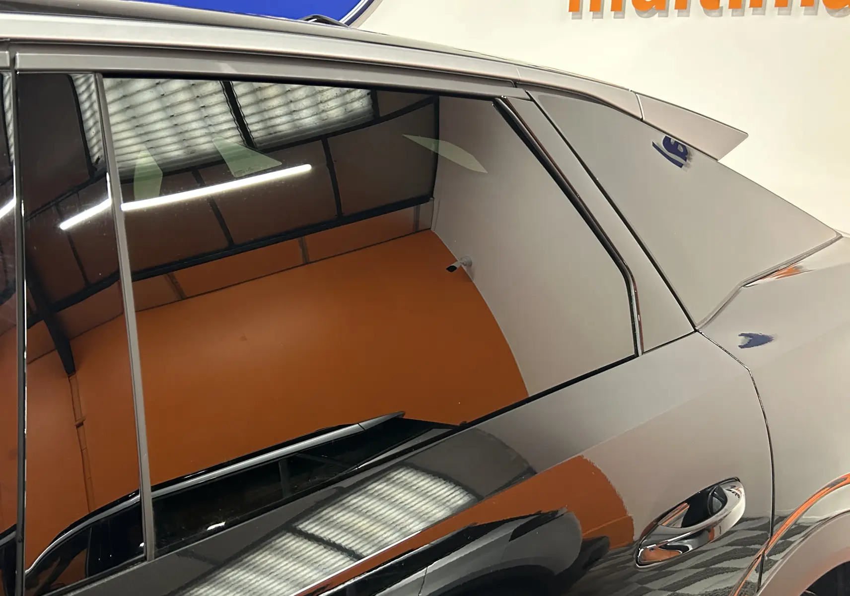 Vue latérale droite rapprochée du Peugeot 3008 noir 2025, mettant en valeur la finition brillante et les lignes du hayon.