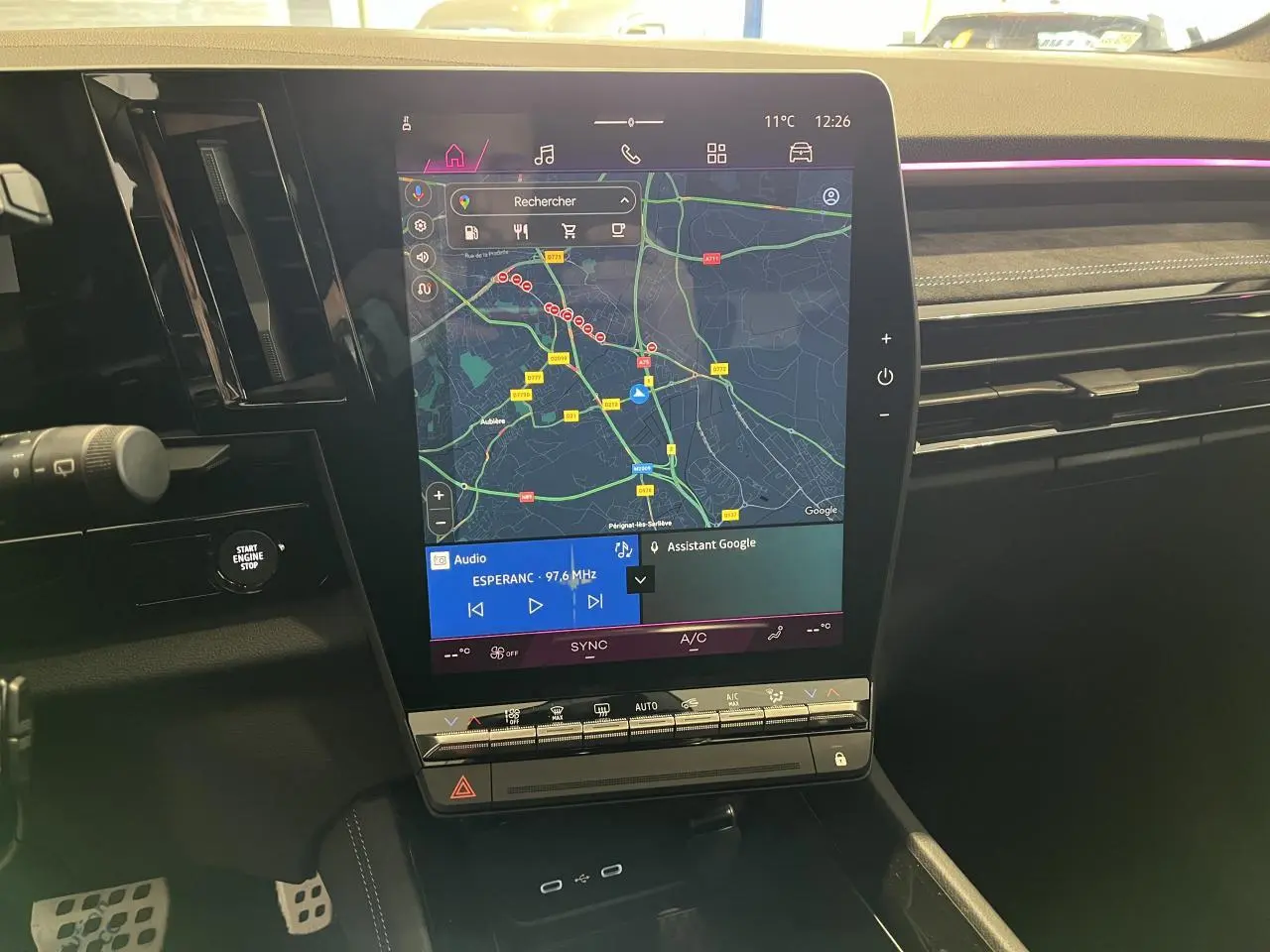 Vue rapprochée de l’écran tactile central du Renault Austral 2025 affichant la navigation et la radio, intérieur noir.