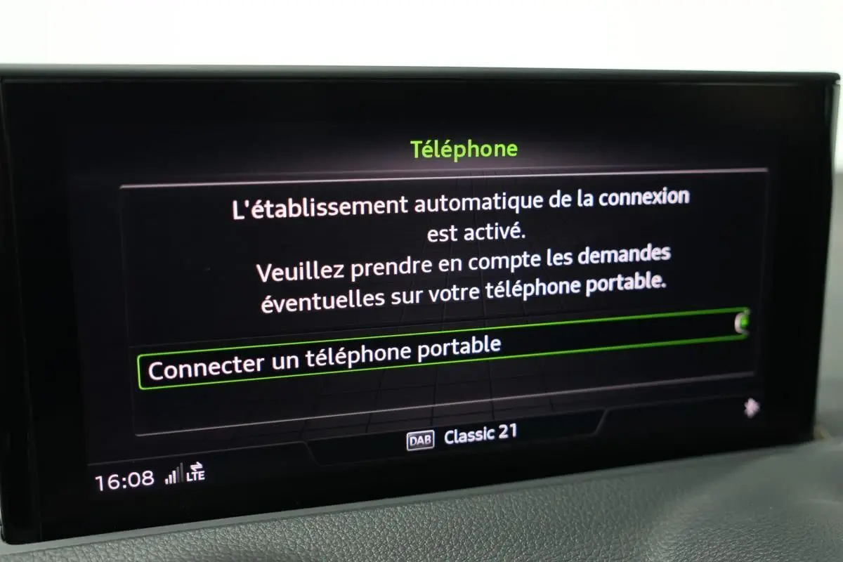 Écran central de l'Audi Q2 gris montrant le menu de connexion Bluetooth pour téléphone portable.